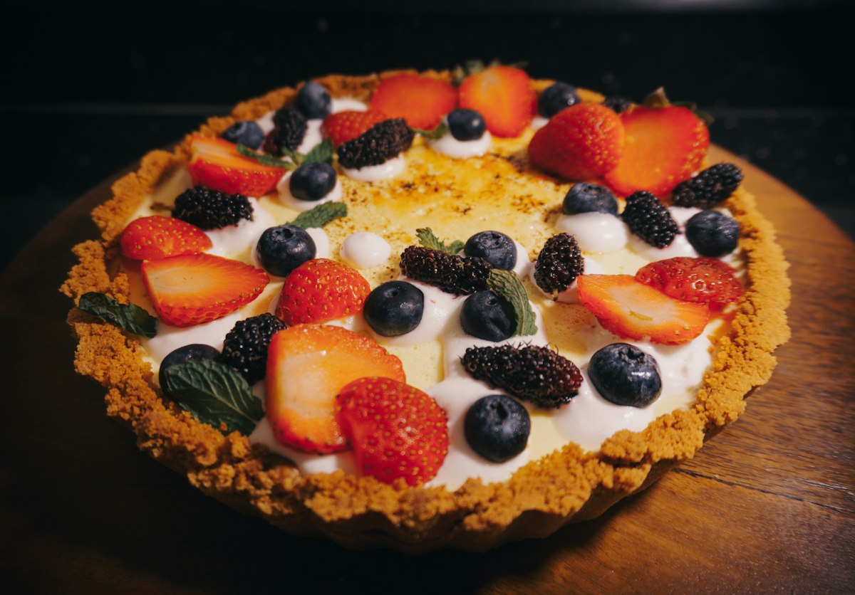 An almond crust tart filled with vanilla cream and covered in fresh berries
