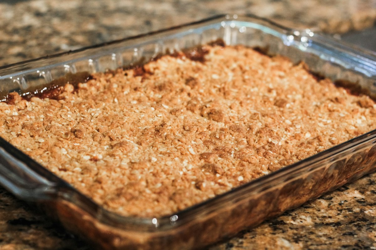 An apple crisp with a golden cinnamon oat topping in a baking dish