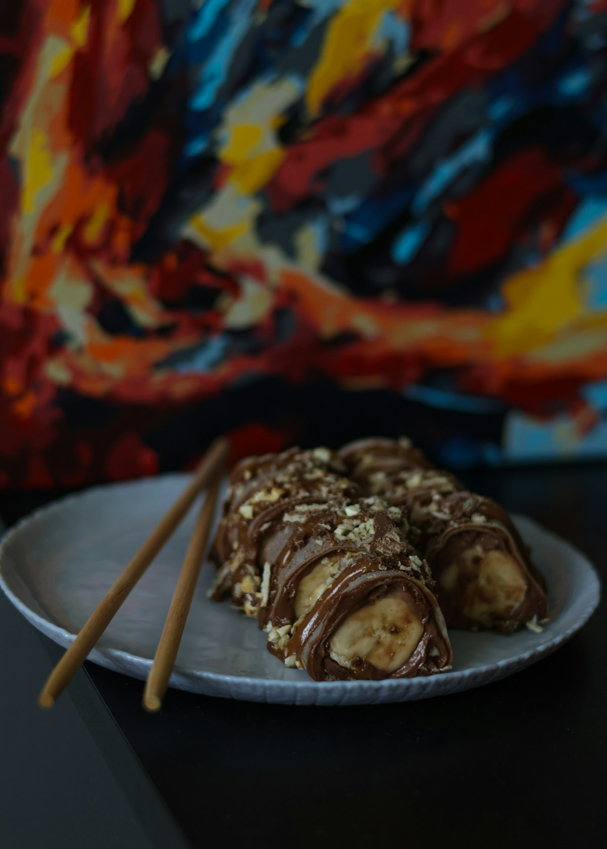 Chocolate-coated banana pieces scattered with chopped nuts