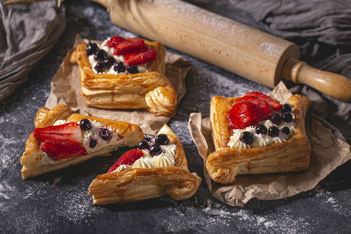 Pastry tartlets filled with cream and topped with strawberries and blueberries