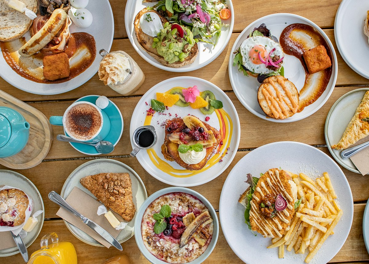 An overhead brunch spread of pancakes, eggs, waffles and coffee