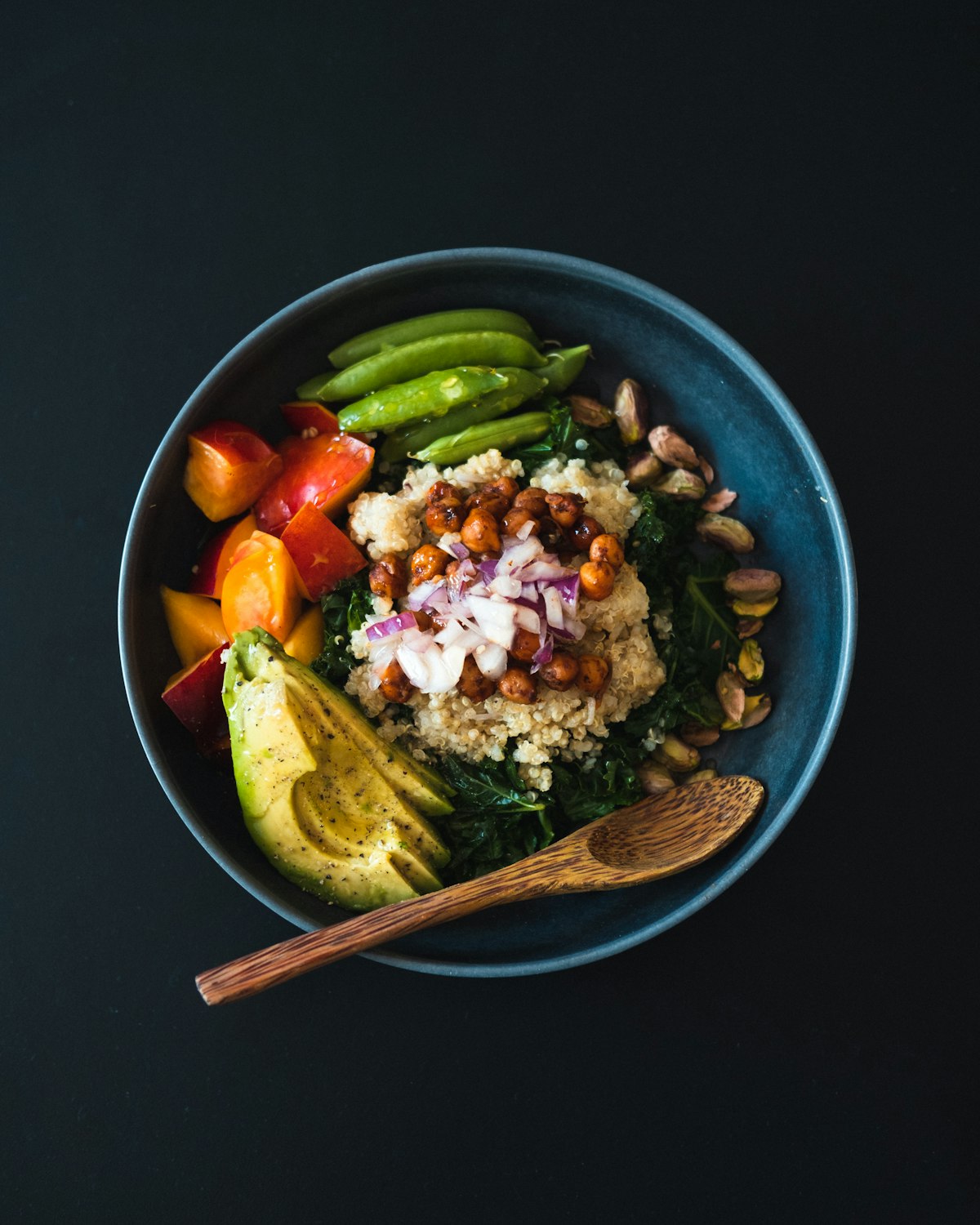 A rice bowl with avocado, sugar snap peas, chickpeas and pickled vegetables