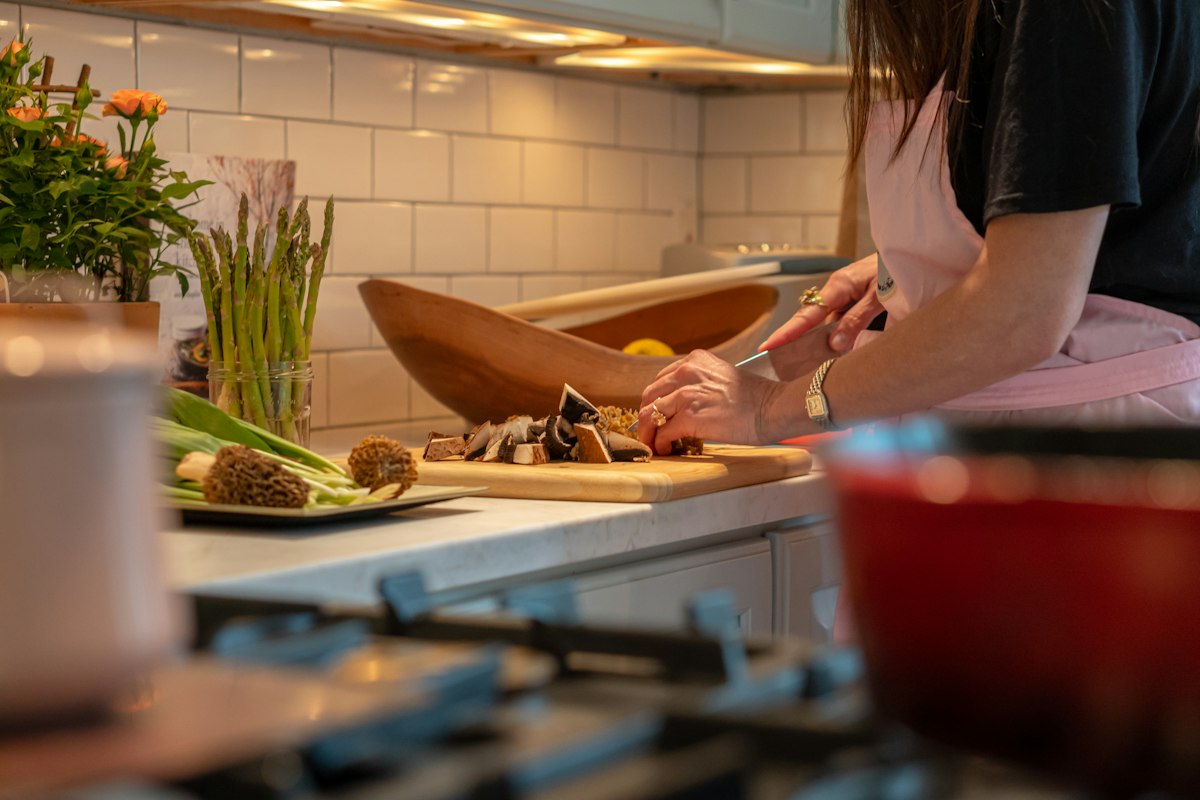 A beginner cook preparing vegetables in a home kitchen
