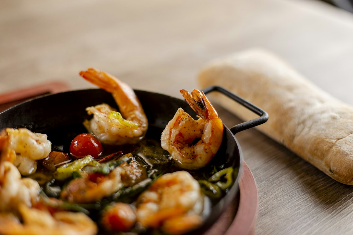 Lemon herb shrimp in a pan sauce with cherry tomatoes and bread