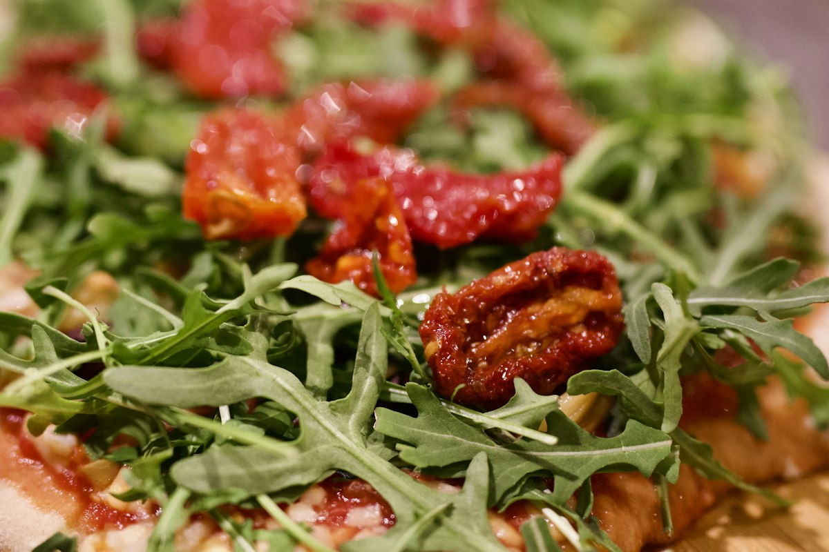 A flatbread topped with rocket, blistered tomatoes and cheese