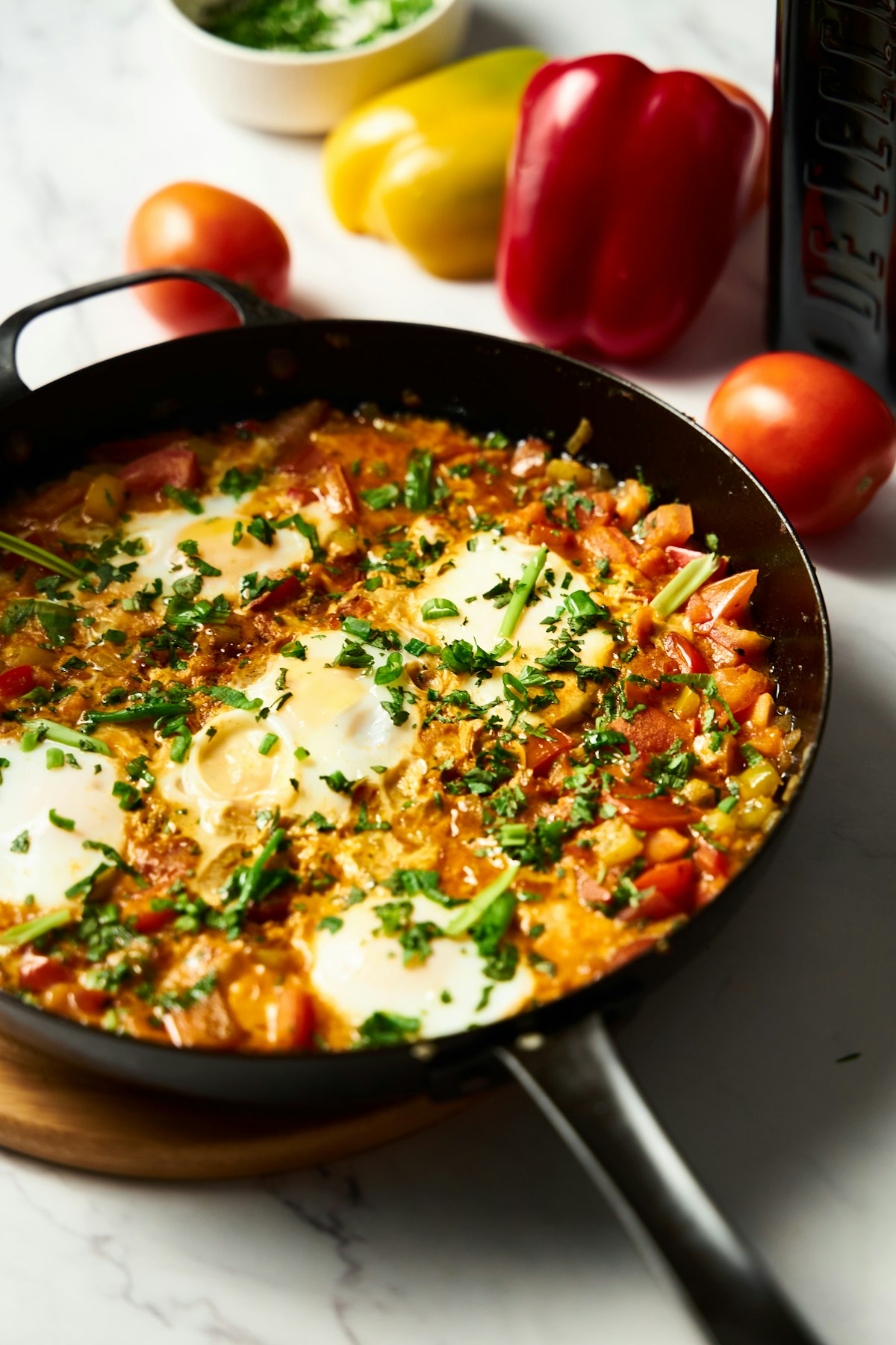 Eggs poached in a spiced tomato and pepper sauce in a black skillet