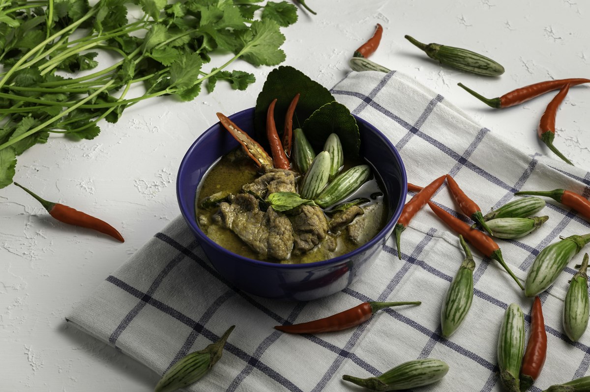 A bowl of Thai green curry with chicken, Thai aubergines and chillies